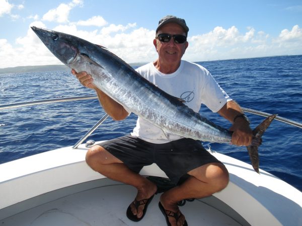 guy holding a wahoo fish he caught