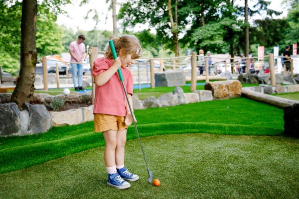 Young girl playing mini golf